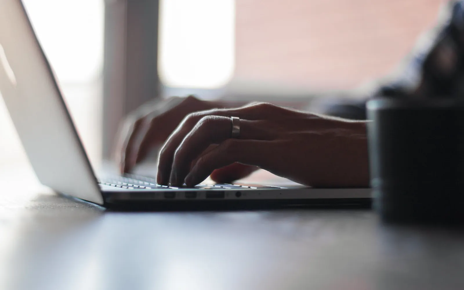 Hands typing on a laptop keyboard